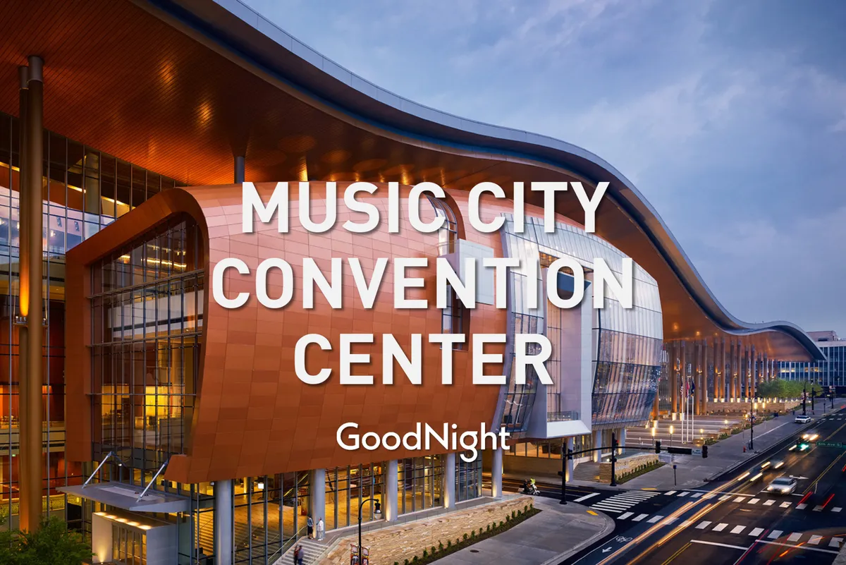 A dramatic view of Nashville's Music City Center with its curved roof and vibrant orange facade, highlighting the city’s dynamic event scene and iconic architecture.