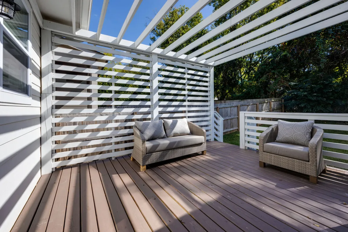 An inviting rooftop deck with comfortable seating areas, decorative pillows, and a wooden deck. The space is open and peaceful, ideal for socializing, enjoying morning coffee, or relaxing in the evening with friends.